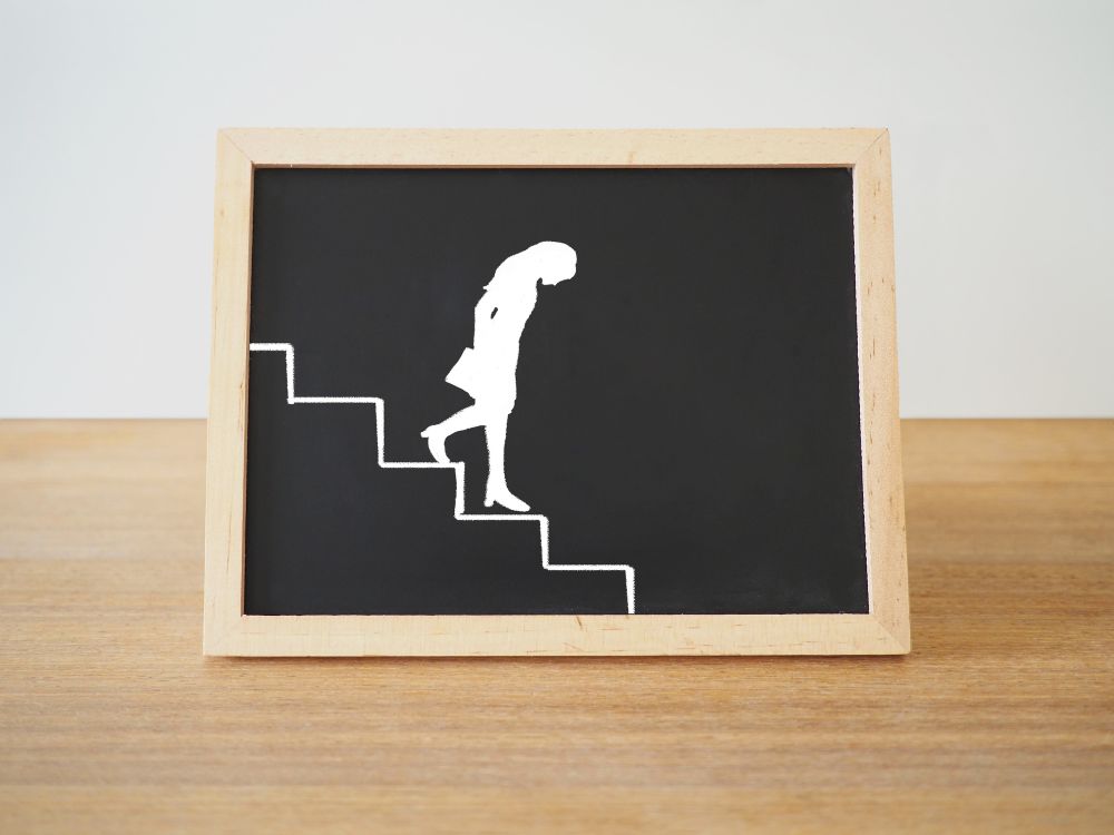 黒板に書かれた階段を降りす女性の絵